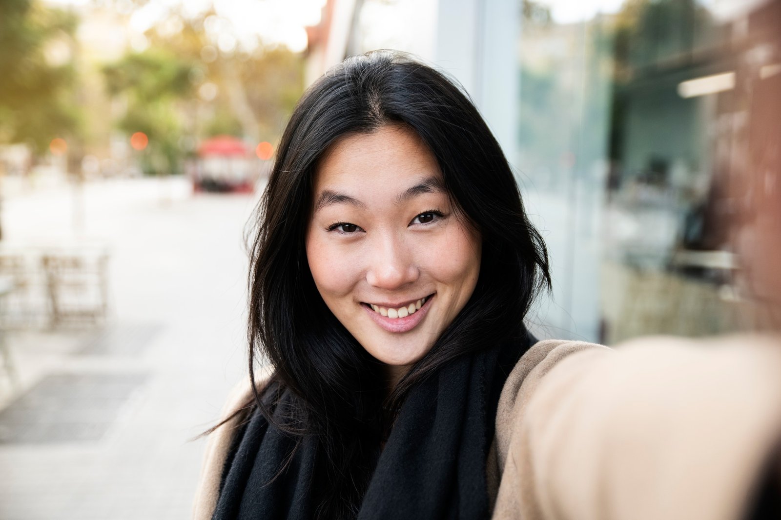 happy young smiling woman taking a self portrait photo in the city - portrait of young japanese